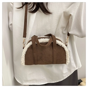 Détail d'un sac en suédine marron avec bordure en polaire blanche et boucles dorées