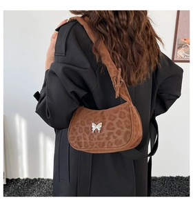 Detail of leopard print hobo bag with silver butterfly charm on soft faux suede