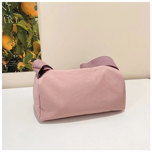 Detail of pink nylon crossbody bag featuring a wide purple strap and lightweight fabric