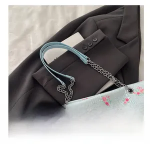 Detail of floral bucket bag featuring light blue pleats with rose and bow patterns
