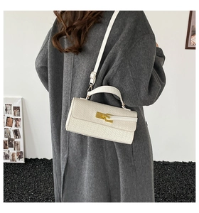Détail de la texture en cuir tressé blanc avec fermoir doré et bandoulière réglable