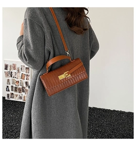 Vue arrière d'un sac marron à texture tressée avec fermoir doré porté à l'épaule