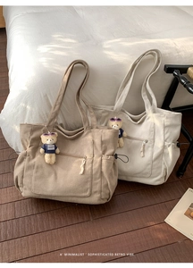 Nahaufnahme der Cord-Tasche mit Frontreißverschluss und Plüschbär-Anhänger-Detail