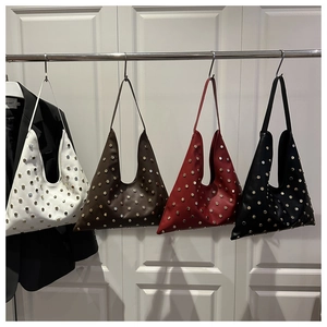 Détail montrant divers coloris de sacs hobo à clous en blanc, marron, rouge et noir élégant