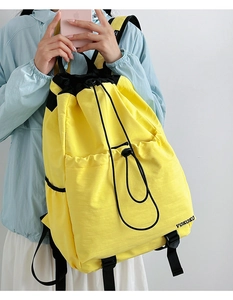 Close-up of bright yellow waterproof drawstring backpack with VOKOKO logo and black straps