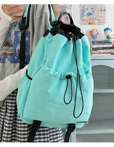 Detail of mint green drawstring backpack showing waterproof nylon and VOKOKO logo