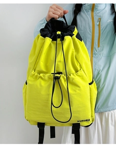 Detail of the bright yellow drawstring backpack made from textured nylon with buckle closure