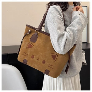 Détail de la broderie chat sur un sac cabas marron avec des anses en cuir raffiné