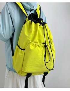 Fluorescent yellow drawstring backpack with nylon texture and black woven shoulder straps