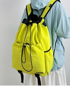 Detail view of the yellow drawstring backpack showing the VOKOKO logo and side pocket