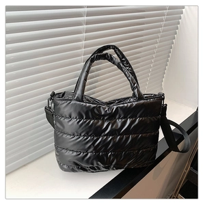 Détail du sac fourre-tout noir matelassé avec texture brillante et finitions soignées