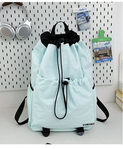 Detail of mint green nylon drawstring backpack with VOKOKO logo and front pocket
