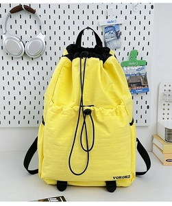 Detail of vibrant yellow drawstring backpack with black accents and durable nylon texture