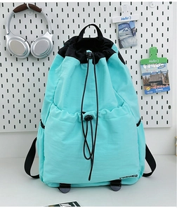 Close-up of a teal drawstring backpack featuring black handles and a sleek brand logo
