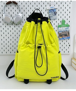 Detail view of fluorescent yellow drawstring backpack with nylon texture and dual pockets