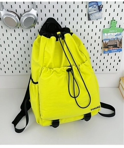 Detail of neon green nylon drawstring backpack with VOKOKO logo and adjustable black straps