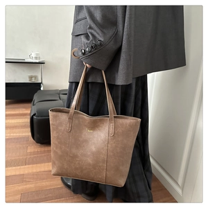 Gedetailleerde macro van de bruine grote tote bag met gouden letters en matte textuur