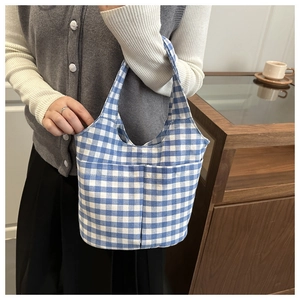 Detail der blau-weiß karierten Handtasche mit zwei Fronttaschen, von Model gehalten