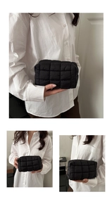 Detailaufnahme einer schwarzen gesteppten Kosmetiktasche mit weicher Puffer-Textur und Gitter