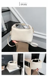 Detail view of cream white leather handbag with gold hardware and adjustable strap