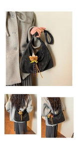 Détail du sac hobo noir avec un charme d'ours brun et des glands tressés colorés