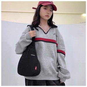 Detail of a casual gray nylon crossbody bag with fashion tag and durable shoulder strap