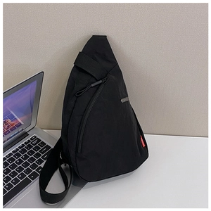 Detail of water-resistant nylon crossbody bag with adjustable strap and fashion label