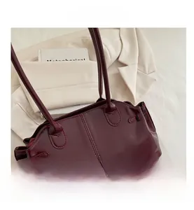 Detailed close-up of dark wine red wax leather tote bag with decorative side buckle