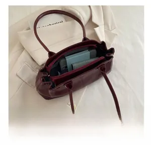 Interior view showing the large capacity and organized compartments of the burgundy tote bag