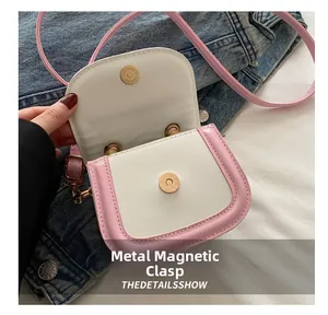 Detailed view of the contrast color crossbody bag with metallic magnetic snap closure