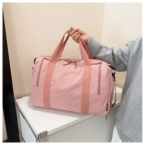 Close-up of pink nylon fitness bag with side zippers and smooth durable fabric texture