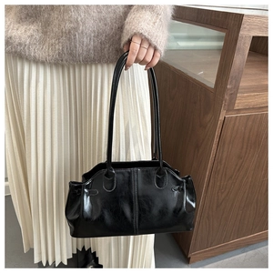 Detail of vintage oil wax leather shoulder bag being carried on a woman's shoulder