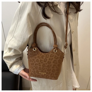 Close-up of leopard print tote bag with braided handles and adjustable shoulder strap