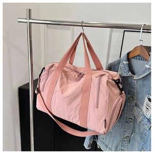 Detailed close-up of pink nylon fitness bag with lavender embroidery and side zipper pocket