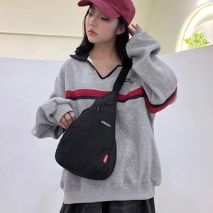 Women's minimalist black nylon chest bag with adjustable strap and fashion tag
