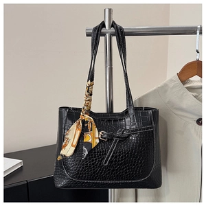 Detailed view of black crocodile pattern faux leather tote bag with silk scarf accessory