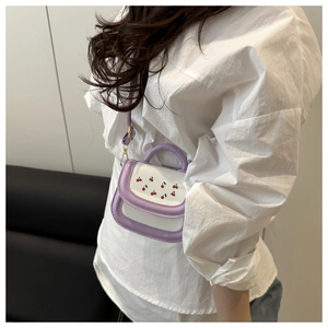 Mini crossbody bag with cherry print and purple trim shown on a model