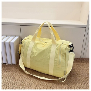 Close-up of the bright yellow nylon travel bag showing the smooth zipper and strap texture