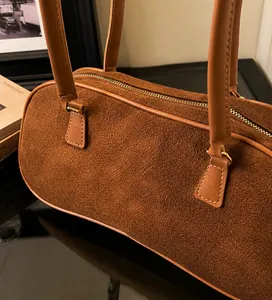 Detailed view of brown faux suede texture and zipper closure on vintage shoulder bag