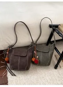 Détail de sacs seaux rétro en marron et vert avec coutures blanches contrastées et bijoux