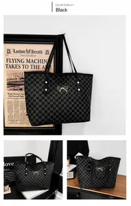 Dettaglio della borsa tote nera con monogramma M e fiocco metallico dorato elegante