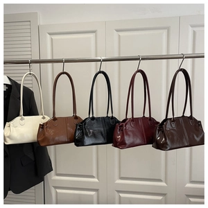 Five assorted colors of glossy oil-wax leather tote bags hanging on a display rack