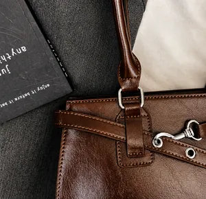 Close-up of premium silver hardware and retro brown leather texture on handbag