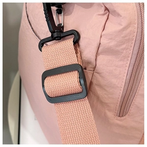 Detail of nylon travel bag shoulder strap hook and durable fabric texture in lotus pink