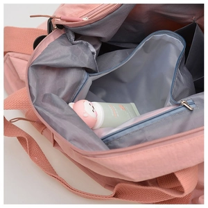 Detail view of pink nylon travel bag featuring a waterproof dry wet separation pocket