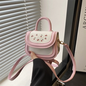 Pink and white patchwork handbag with cherry print, featuring handle and shoulder strap