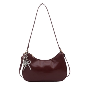 Bolso hobo vintage de cuero brillante burdeos con un colgante decorativo de lazo plateado