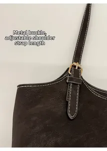 Détail de sac vintage avec boucle dorée et bandoulière réglable en daim marron