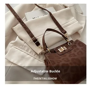 Detail view of adjustable golden buckle and leopard print texture on crossbody bag