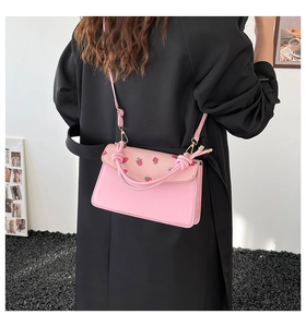 Détail du sac bandoulière rose à motif fraise avec ferrures dorées et cuir PU poli